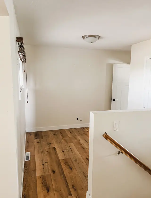 Upstairs hallway and stair landing with warm wood plank flooring