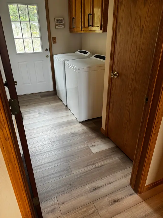 Laundry and mudroom hallway with grey plank LVP flooring